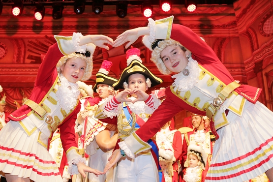 Verkleidete Kinder zeigen Herzen mit Händen