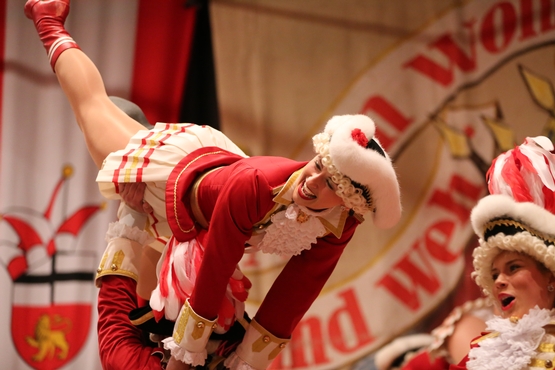 Auf diesem Foto sieht man wie ein Tanzmariechen in einer Hebefigur in der Luft gehalten wird