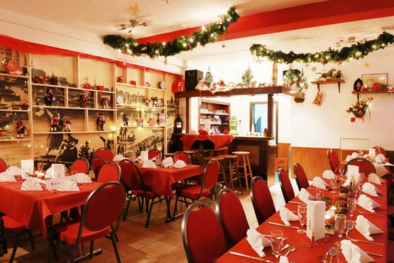 das Zeughaus von innen Kleinere Tische, sowie eine Lange Tafel und vielzählige Stühle. Es hängt Weihnachts-Deko