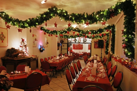 Zeughaus Interior Kleinere Tische, sowie eine Lange Tafel und vielzählige Stühle. Es hängt Weihnachts-Deko