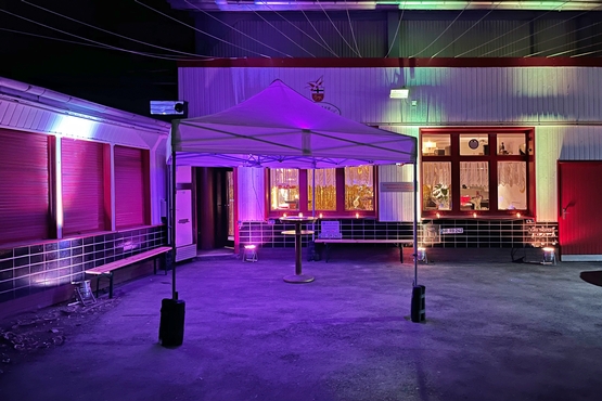 Zeughaus Hof Der bunt beleuchtete Hof des Zeughauses mit Blick auf das rot lackierte Hoftor und einem Pavilion in der Mitte.