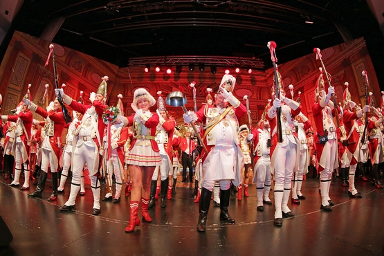 Foto von Ehrengardisten auf der Bühne, die Gardisten halten ihre Gewehre vor sich in die Höhe