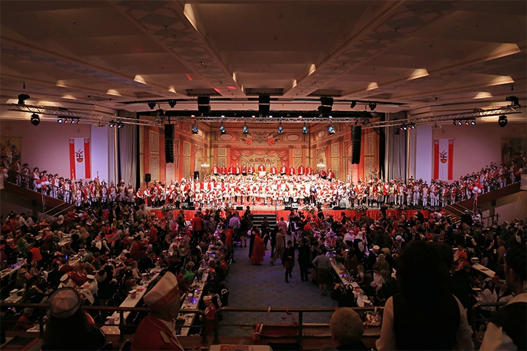 Foto des Saales der Großen Bürgersitzung Foto des rot-weiß geschmückten und mit unzähligen Menschen gefüllten Saales der großen Bürgersitzung
