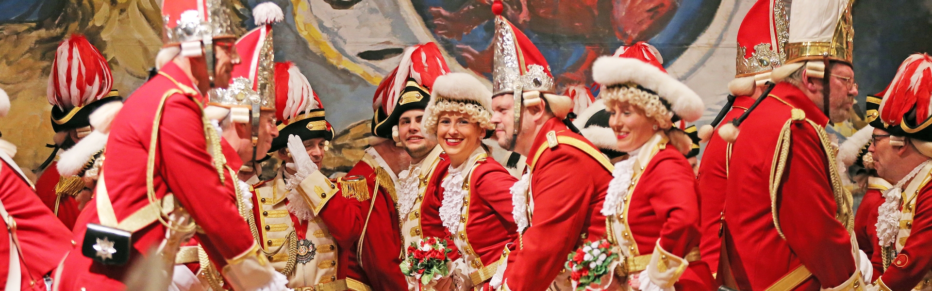 Die Tänzerin schaut, während eines Tanzes der Ehrengarde, lachend in die Kamera.