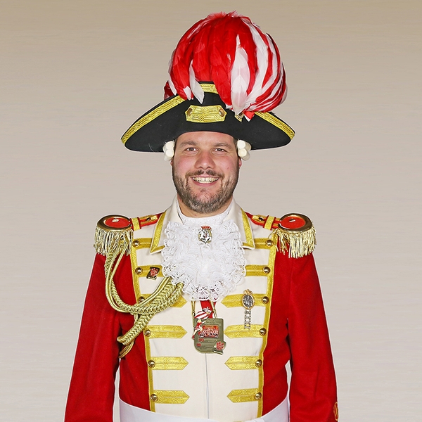 Portrait von Ben Fabry in Uniform vor grauem Hintergrund.