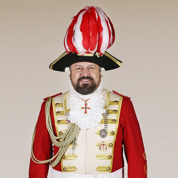 Portrait von Micheal Remmy in Uniform vor grauem Hintergrund.