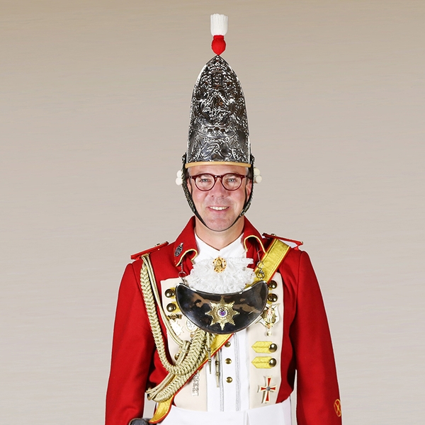 Portrait von Tim Jankowski in Uniform vor grauem Hintergrund.