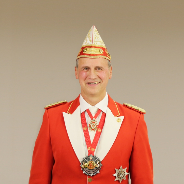 Portrait von Wolfgang Stäblein in Litewka vor grauem Hintergrund.